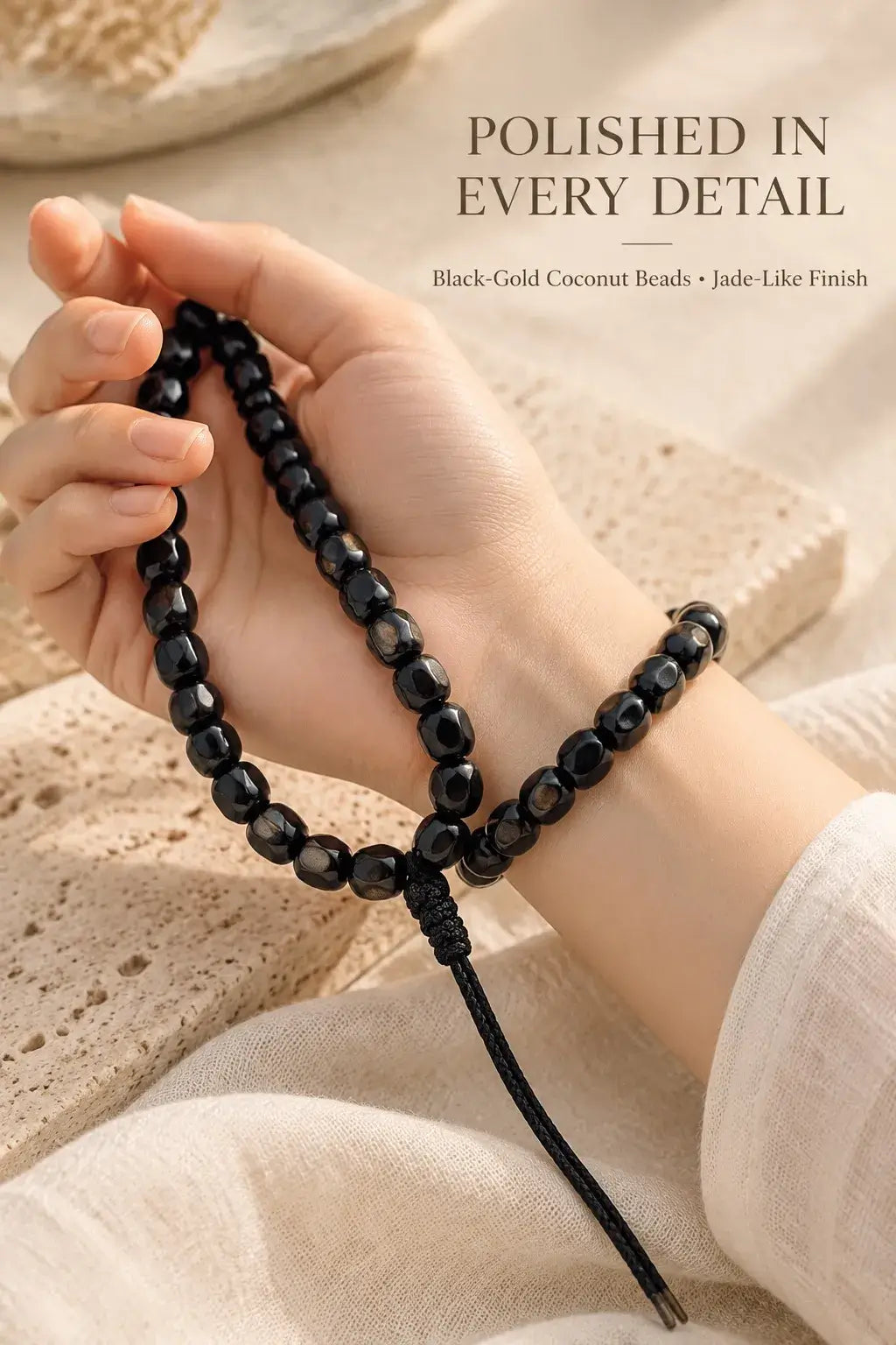 Black-gold coconut handheld beads draped across the hand and wrist