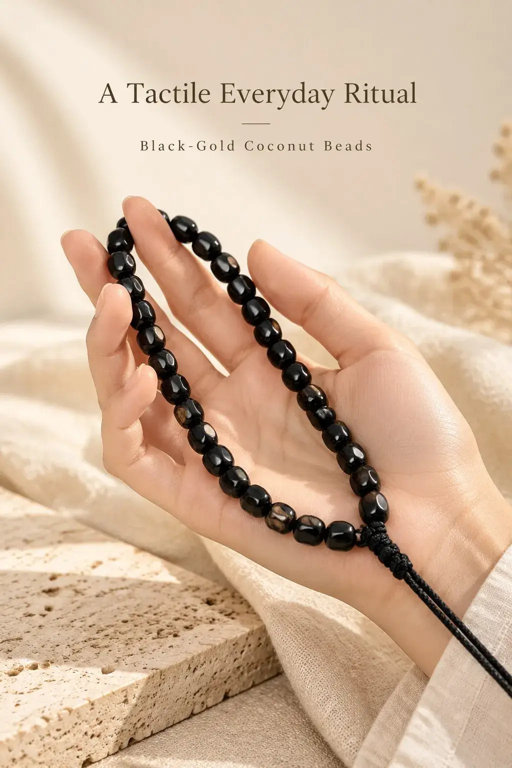 Sculpted coconut Wuxiang beads held in the palm with braided hanging cord