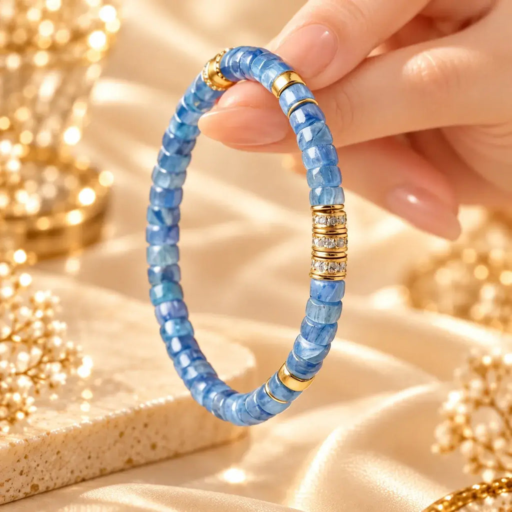 Hand-held view of flat-cut blue kyanite beads and gold-tone details