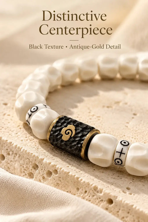 Detail of sculpted pale beads and black-and-gold-tone decorative centerpiece
