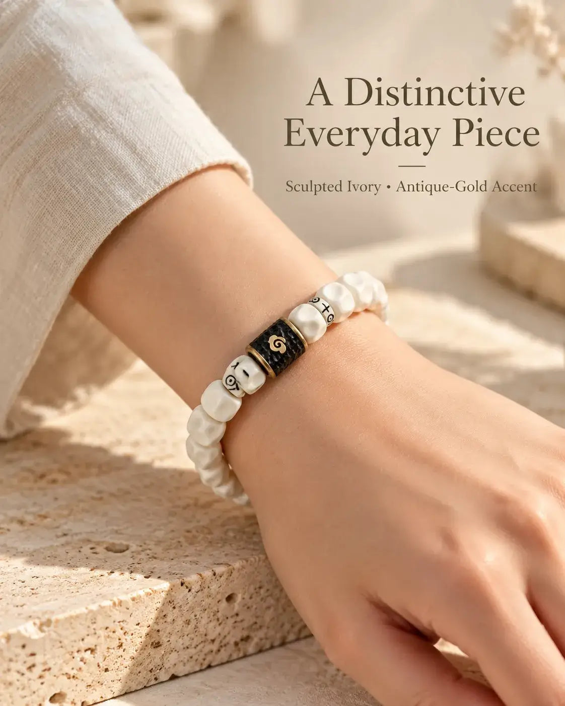 Pale carved bead bracelet styled with a light sleeve