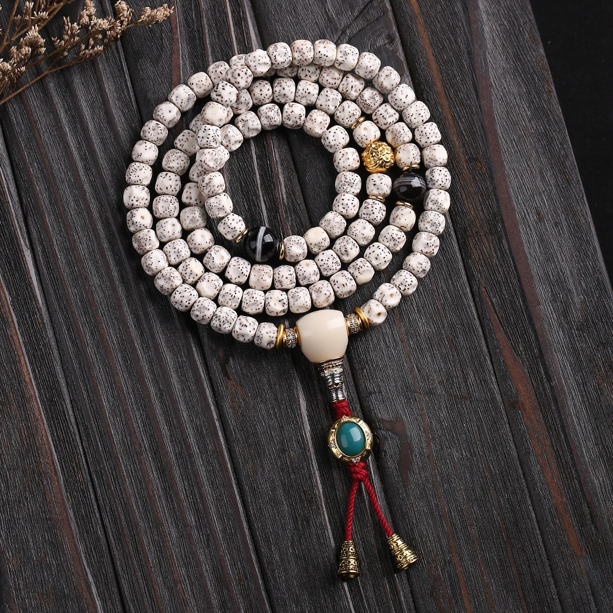 108-bead star and moon Bodhi handheld mala on a dark wood surface with red tassel