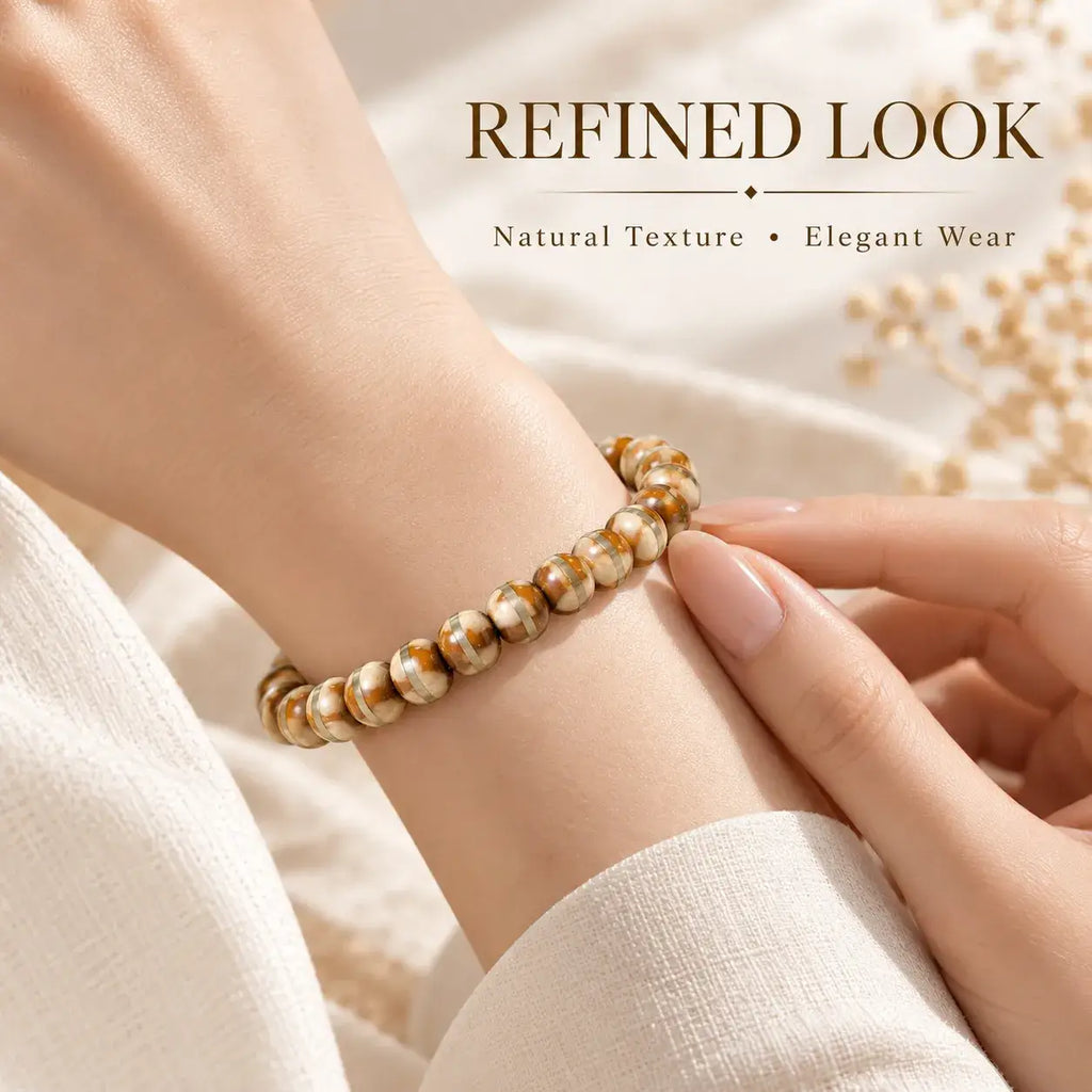 Brown-and-cream seed bracelet styled with a light sleeve