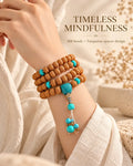 108 bodhi seed mala with turquoise accents wrapped around the wrist